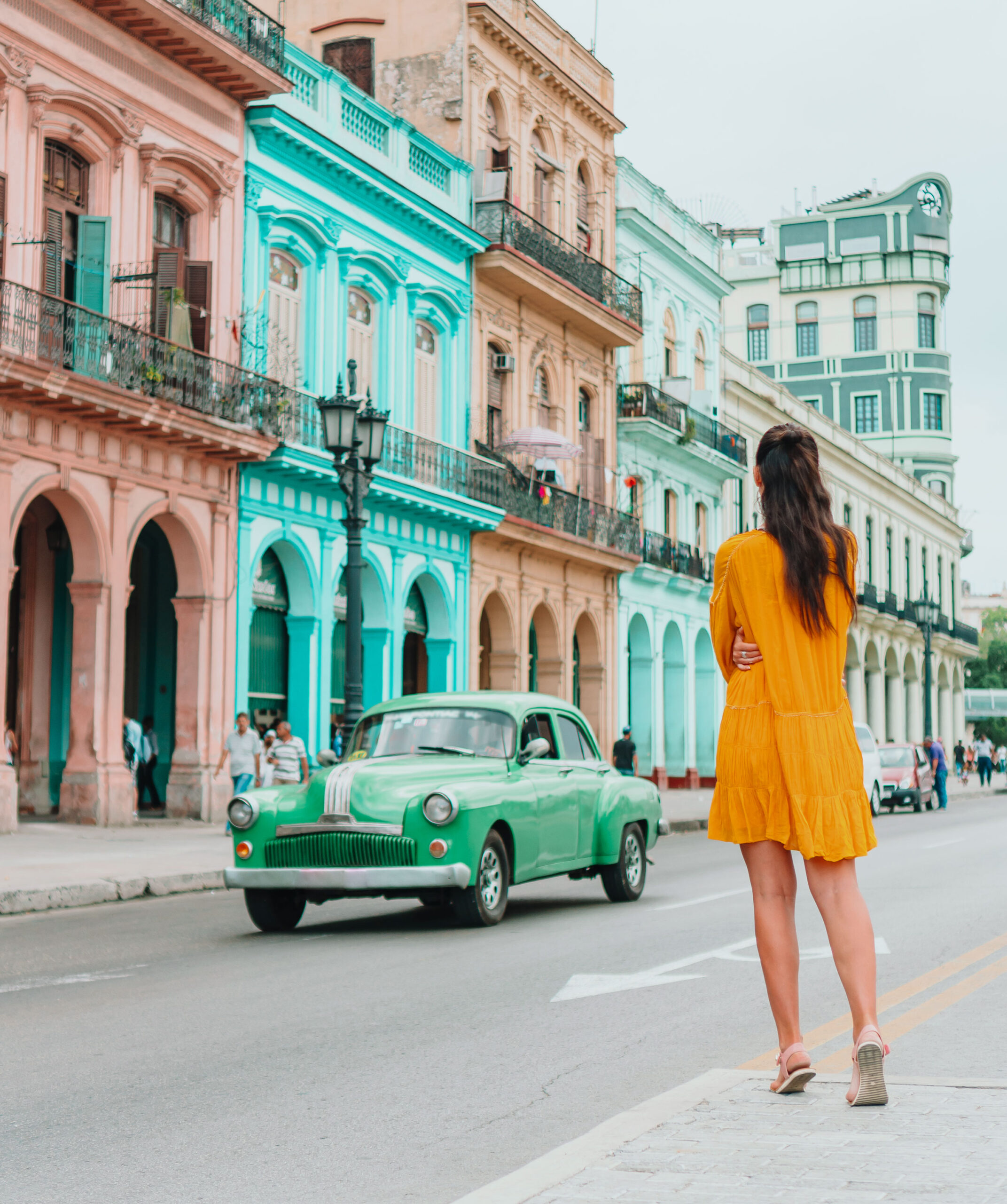 a woman walking down a street in front of a building